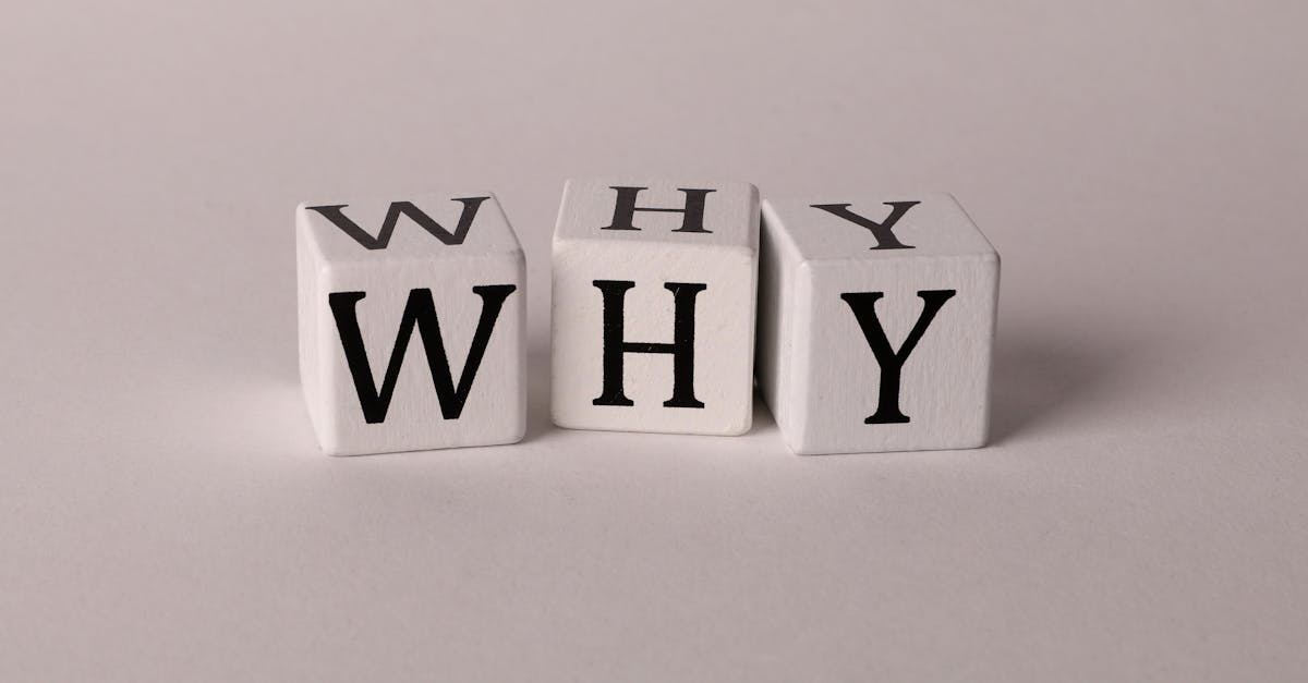 Close-up of lettered dice spelling 'WHY' on a neutral background, ideal for concepts of inquiry or curiosity.